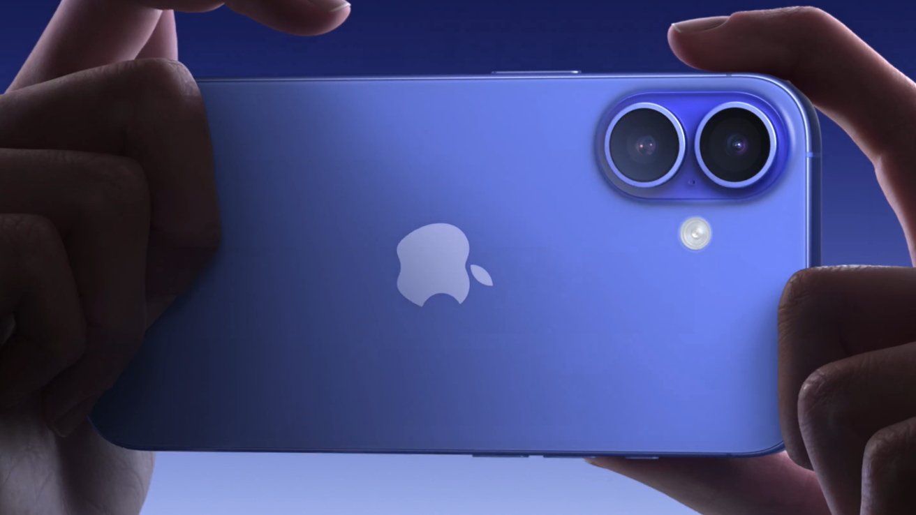 Hands holding a blue iPhone 16 with dual cameras and a prominent Apple logo on the back.