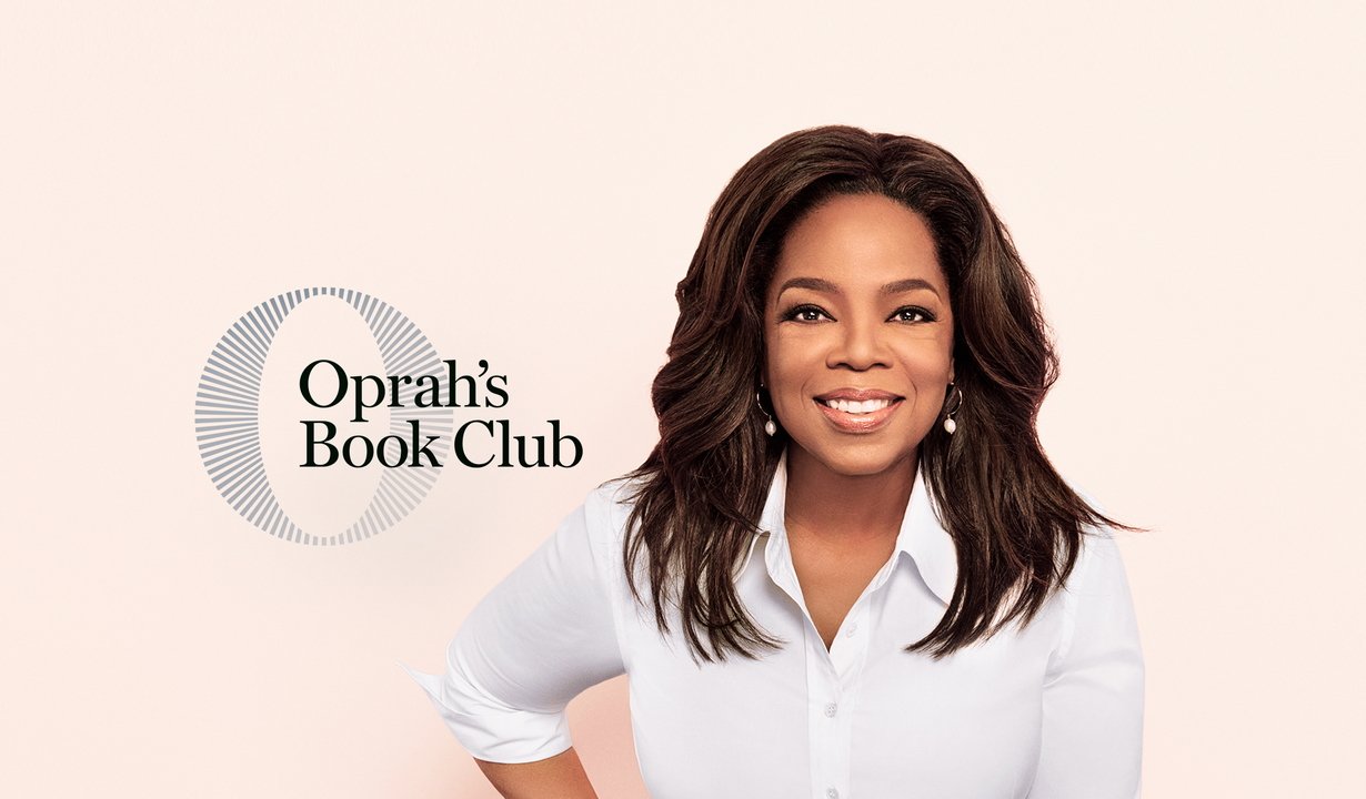 Woman with long dark hair smiles, wearing white shirt; text on left says Oprah's Book Club with circular design.