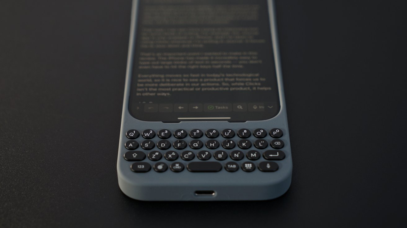 A smartphone with a physical QWERTY keyboard below the touchscreen, placed on a dark surface.