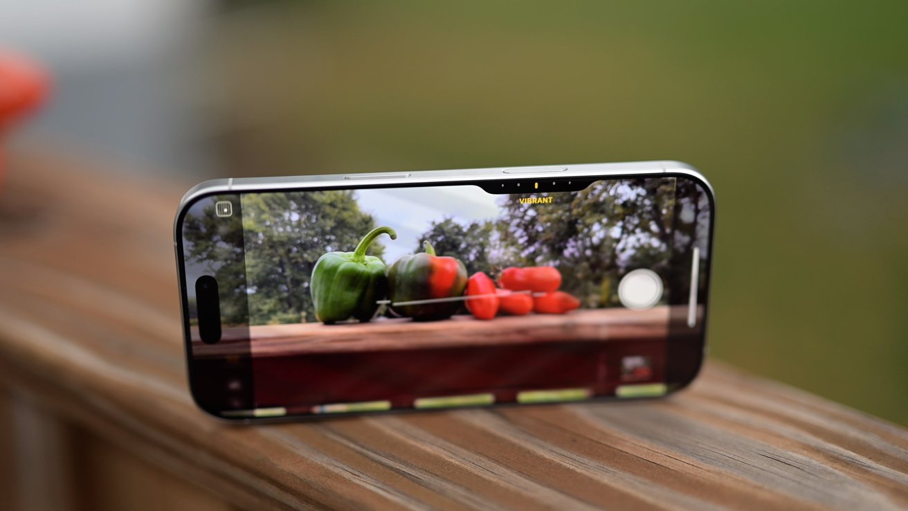 Camera Control button interface on display in the camera app with a pile of vegetables on the iPhone's screen