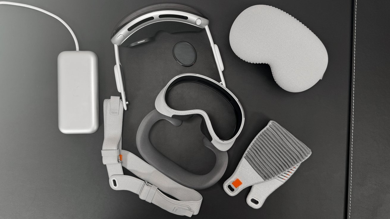 VR headset with head strap, charger, and protective cover, laid out on a black surface.