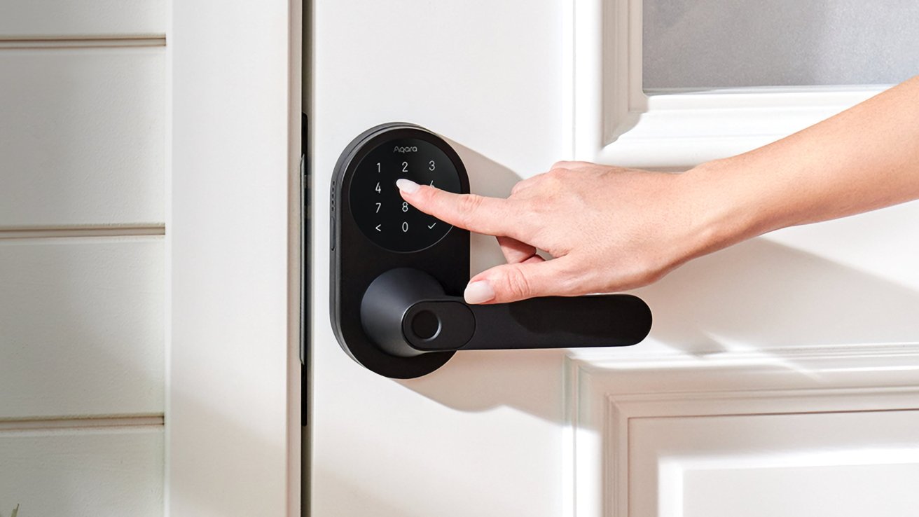 Hand pressing numbers on a digital keypad door lock with a black handle on a white door.