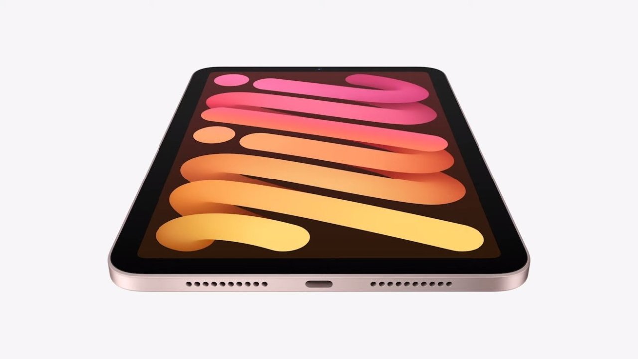 Flat tablet displaying vibrant, abstract orange and pink pattern, with a black border and charging port visible at the bottom.