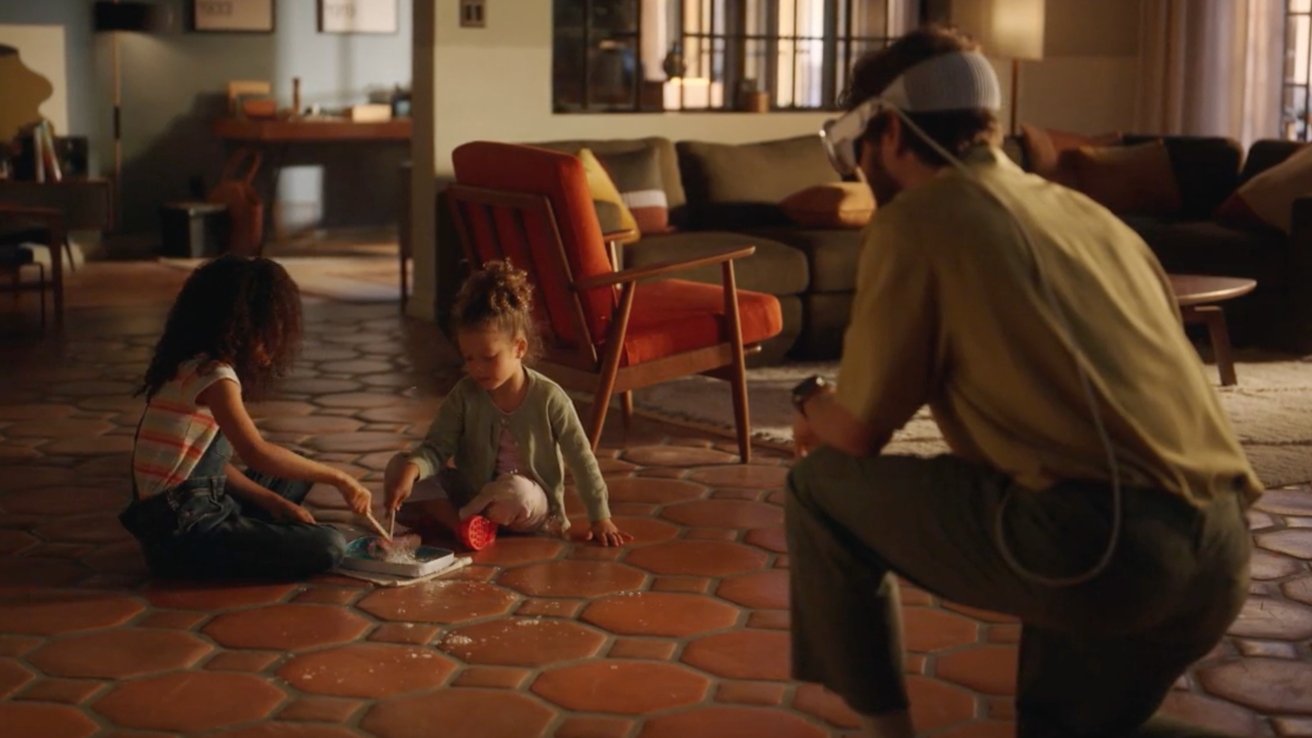 Two children play with a puzzle on the floor while an adult wearing a VR headset kneels nearby in a cozy living room.