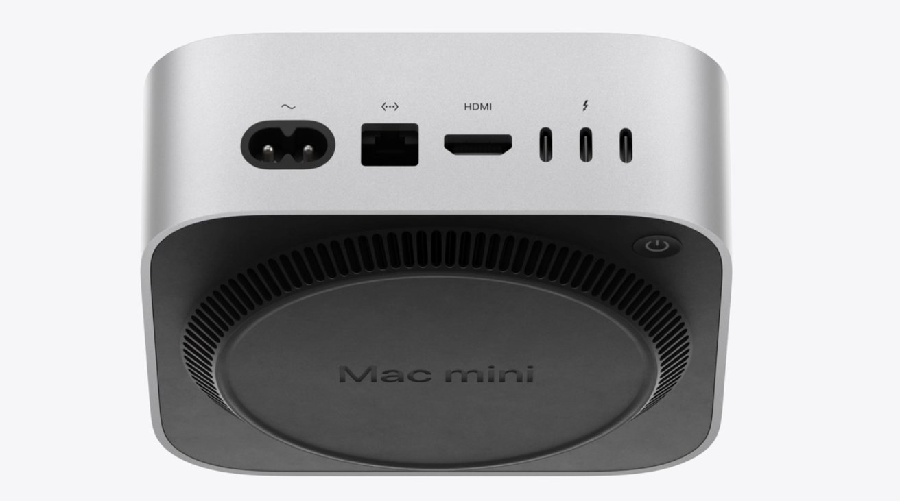 A silver Mac mini with rear ports: power, Ethernet, HDMI, and USB-C. Circular base with 'Mac mini' text and a power button on the side.