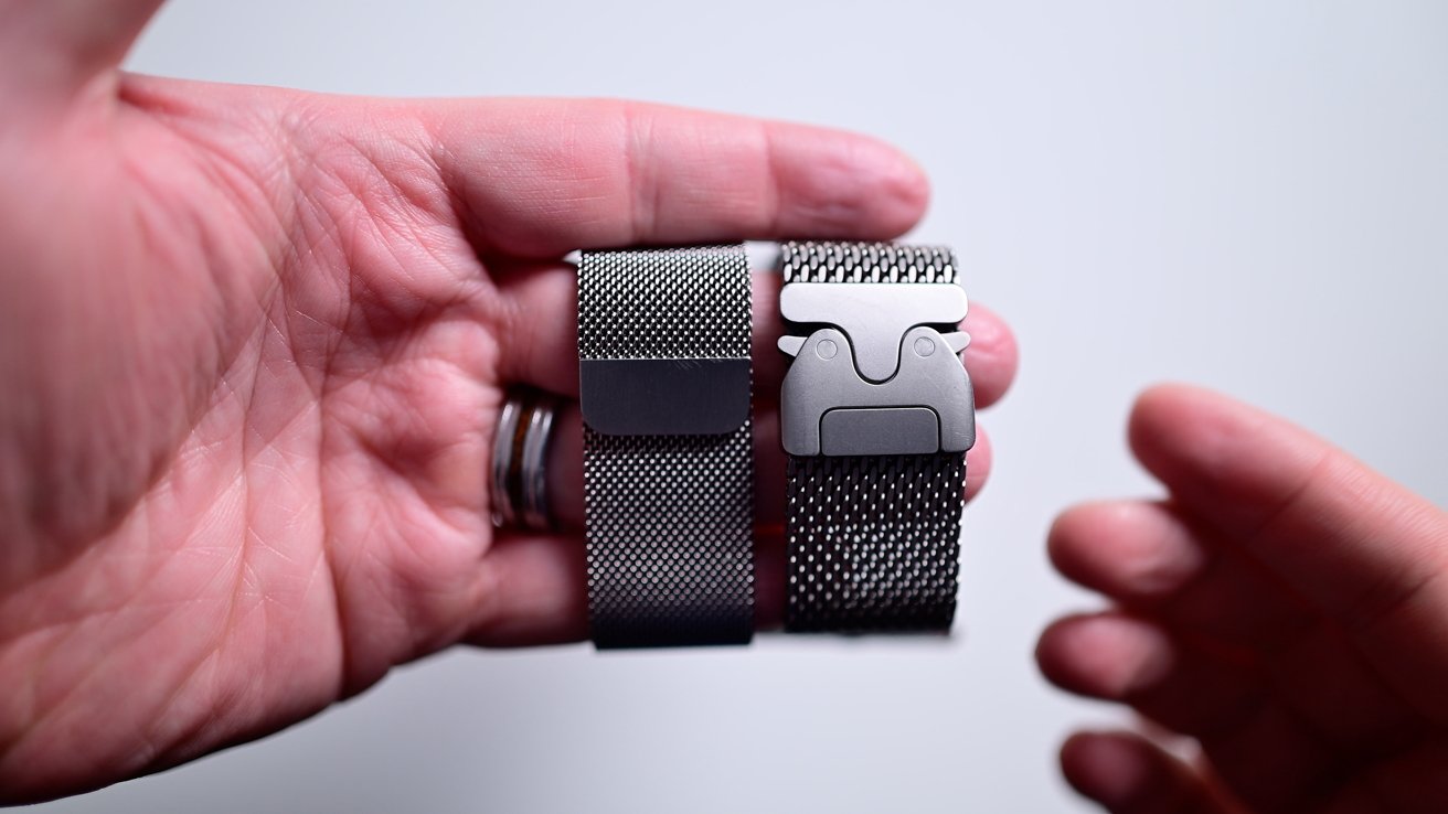 Two hands that hold a pair of silver net watches with metallic buckles against a light background.