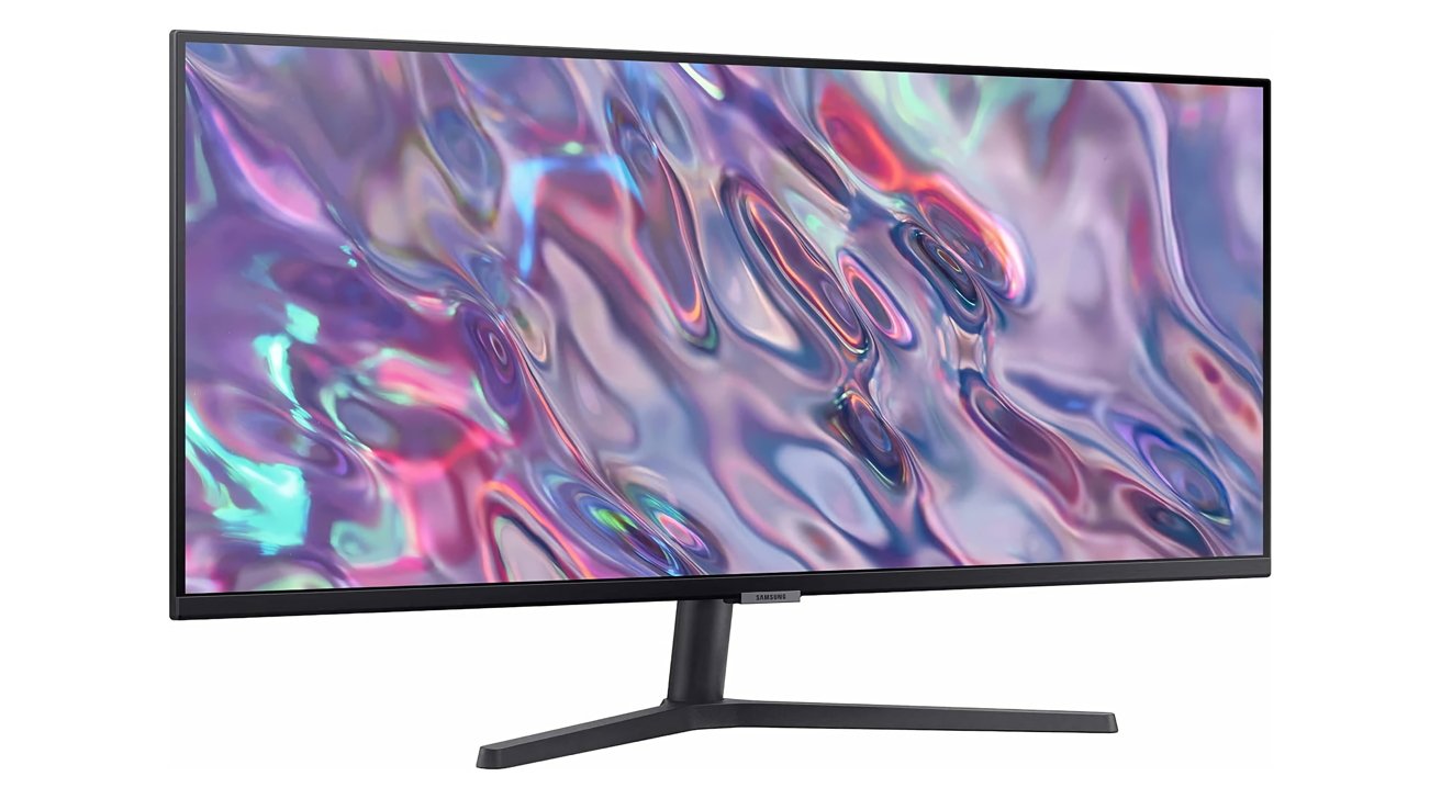 Flat-screen monitor displaying a vibrant, abstract swirl of colors including pink, purple, blue, and green, with a sleek black stand.