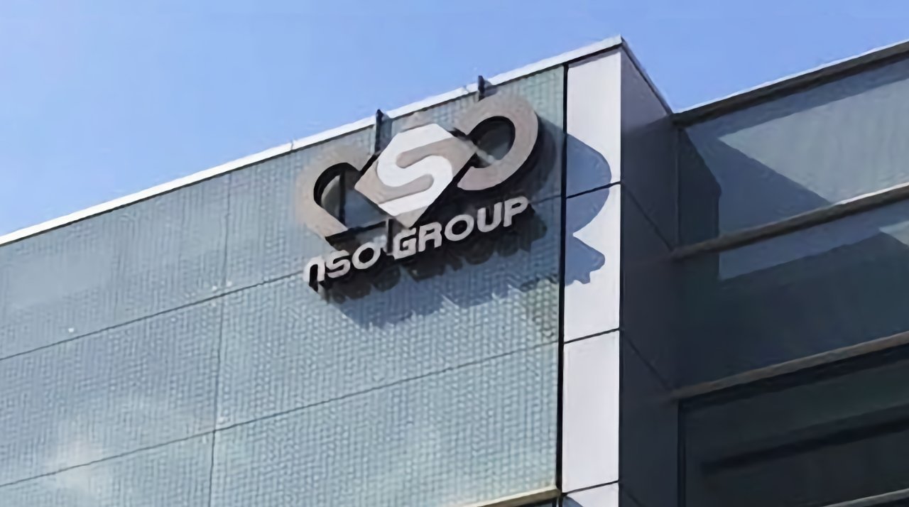 NSO Group logo on the glass exterior of a modern building under a clear blue sky.