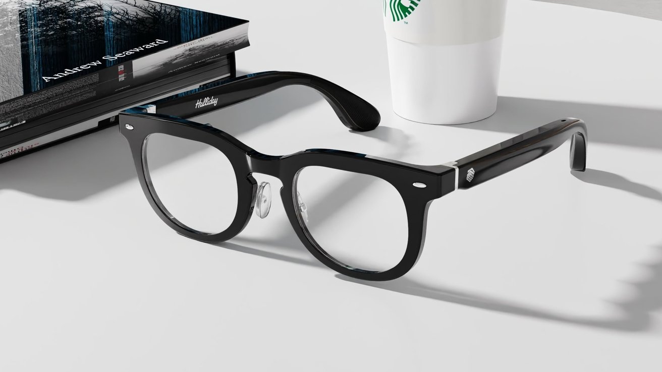 Black glasses on a white surface with a book nearby and a white paper cup in the background.