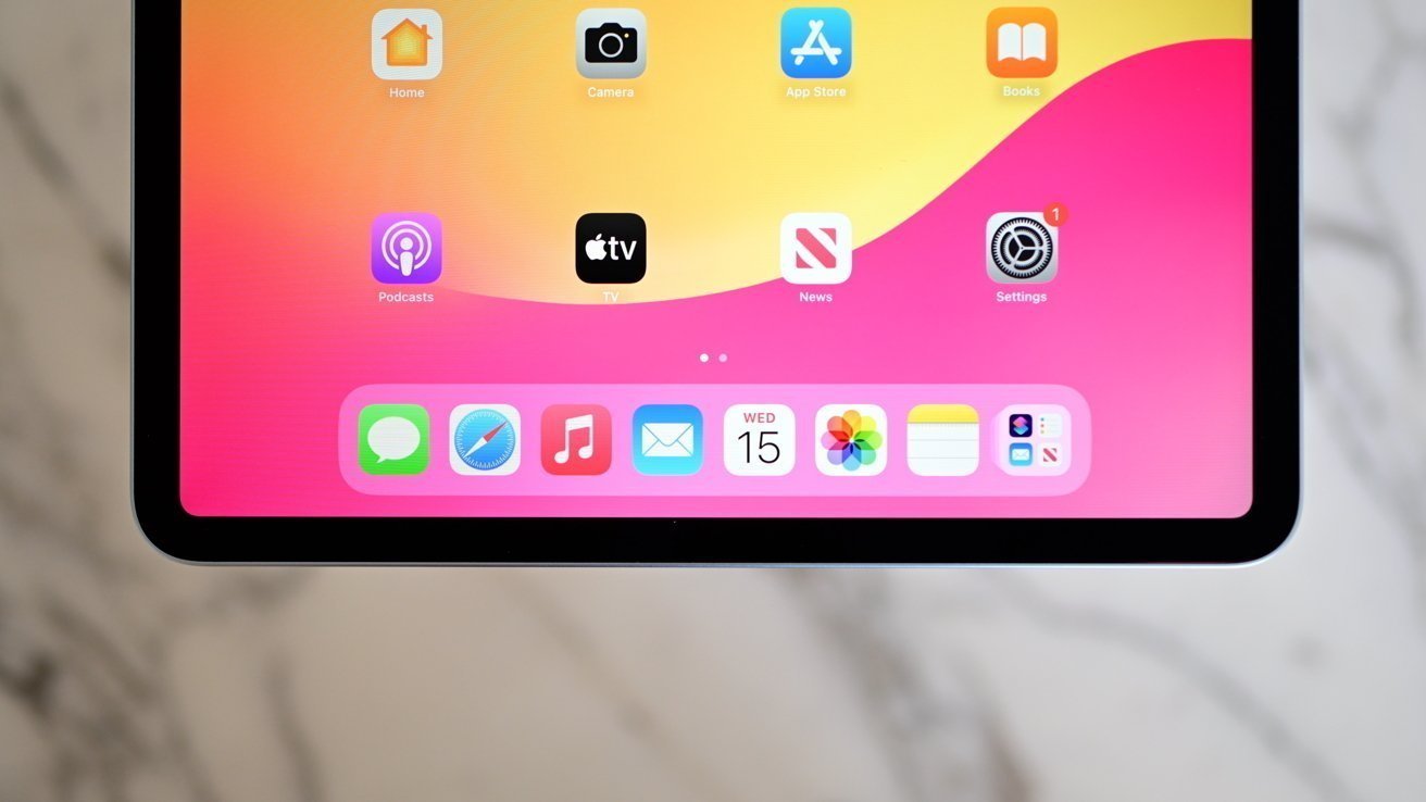 Tablet screen showing app icons against a vibrant pink and yellow gradient background, including Messages, Safari, Music, and Mail apps. Rounded corners and sleek design.