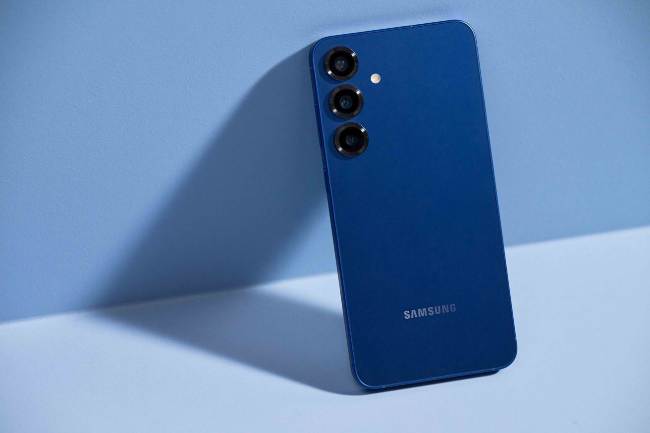 Blue smartphone with three rear cameras arranged vertically, set against a gradient blue background, casting a shadow.