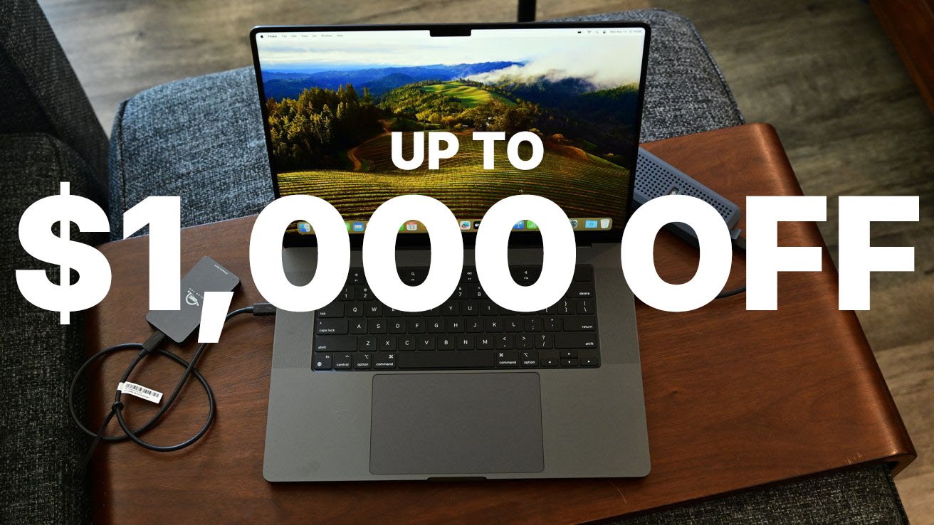 MacBook Pro laptop on wooden table with green landscape screen, charging cable, and text overlay 'UP TO $1,000 OFF'.