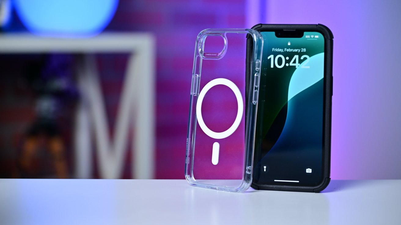 Smartphone on table displays time 10:42, alongside a transparent phone case with a white circle design, set against a blurred purple background.