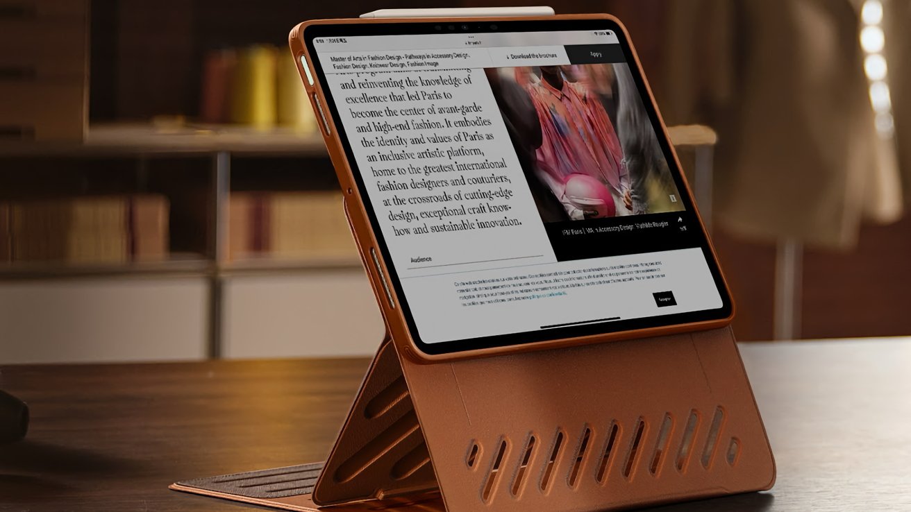 Tablet in brown leather case displaying a webpage with text and an image, positioned on a wooden table in a softly lit room with shelves.