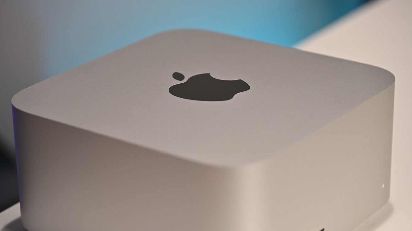 Mac Studio with rounded edges and a black apple logo centered on the top surface.