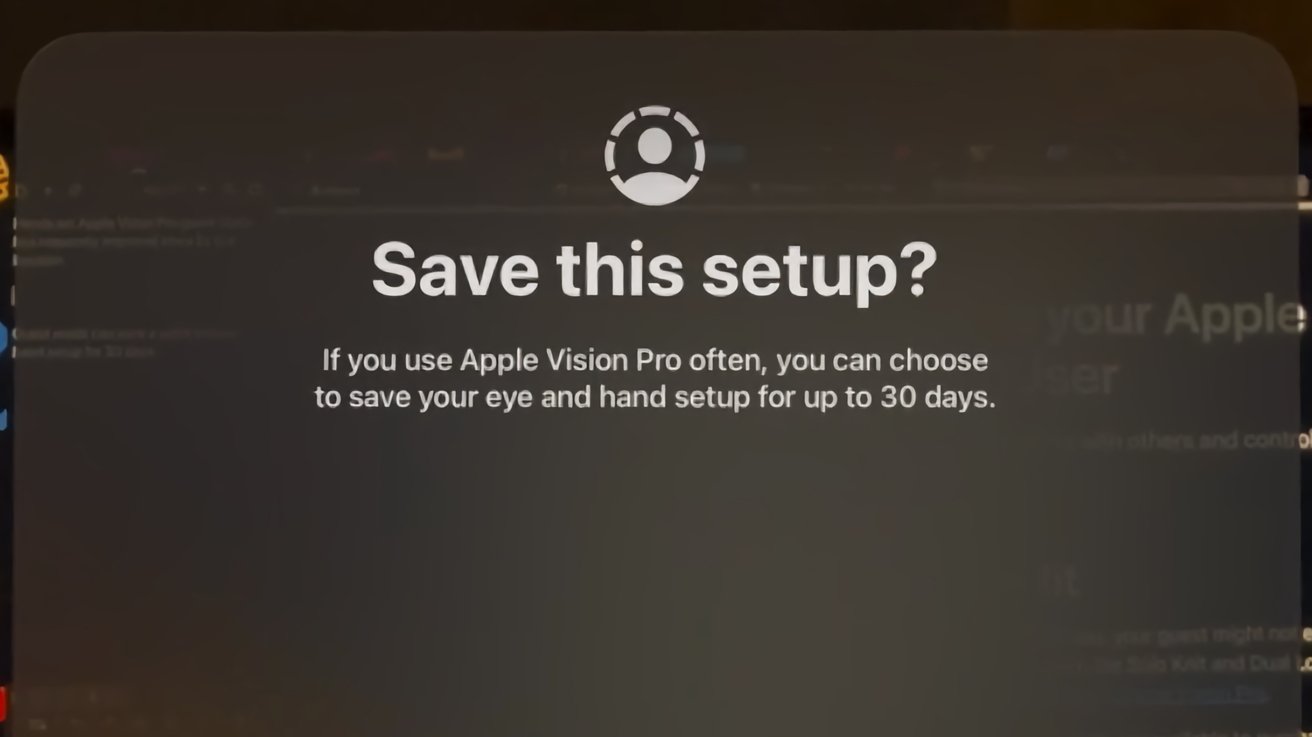 Segera bertanya apakah akan menyimpan pengaturan Apple Vision Pro, dengan ikon seseorang di atas teks dengan latar belakang kabur yang gelap.