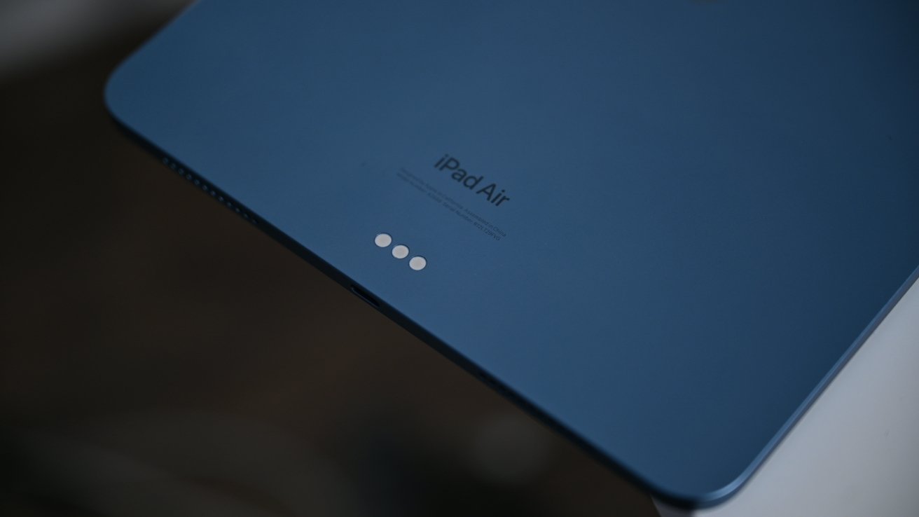 Blue tablet back with 'iPad Air' text and three small circular connectors near the edge.