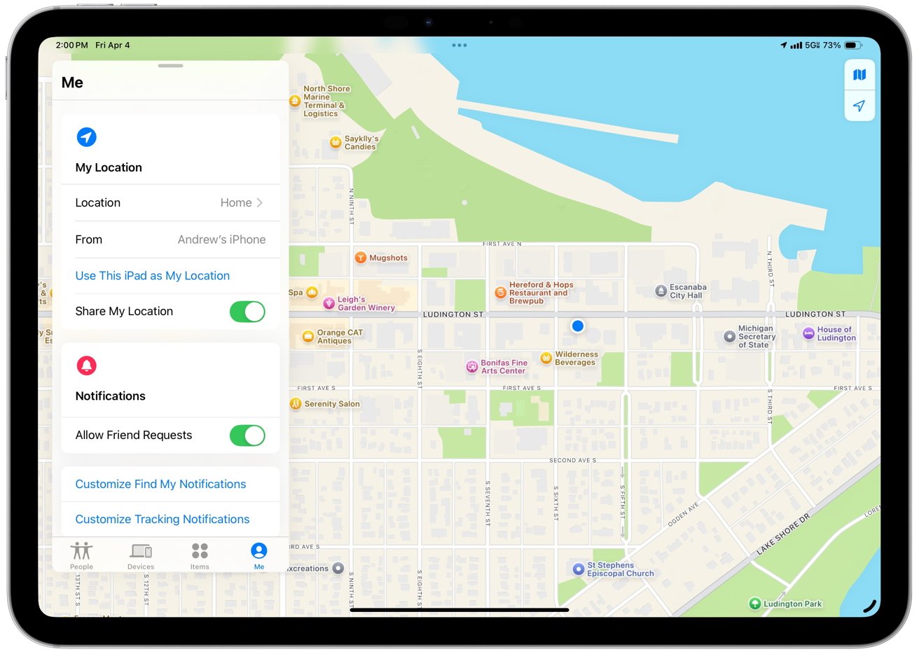 iPad screen displaying a map with location markers and sharing options, including toggles for sharing location and notifications. Map shows streets, businesses, and landmarks near a waterfront.