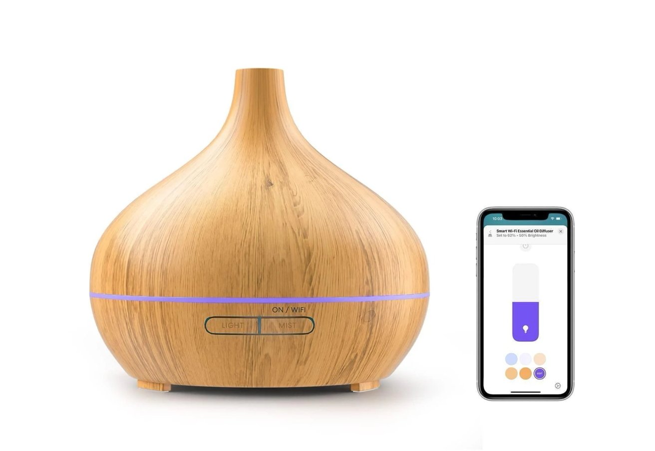 Wooden essential oil diffuser with soft purple light and control buttons, shown next to a smartphone displaying a related app interface.