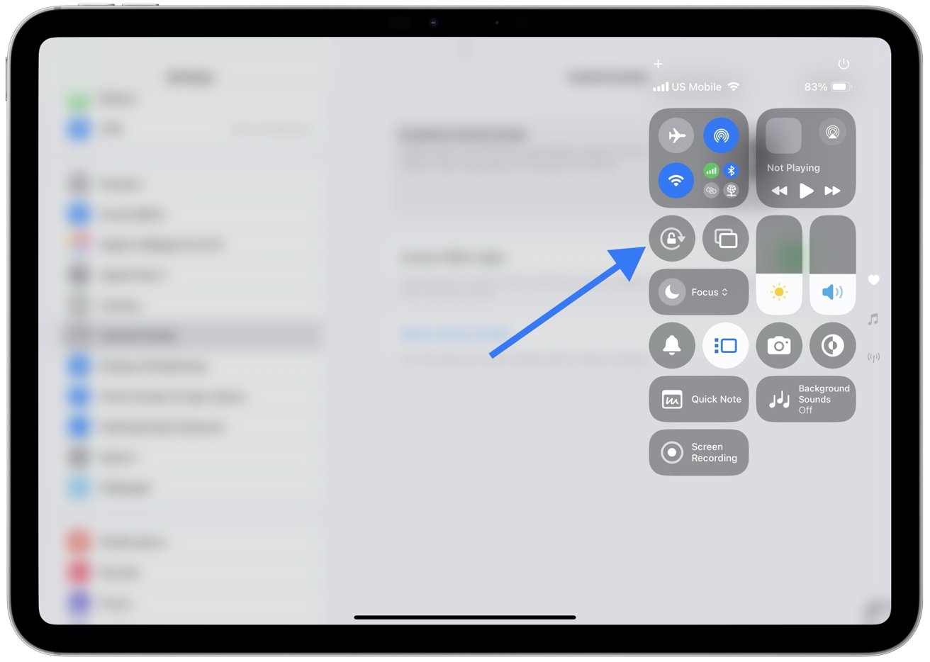 iPad screen showing control center with a blue arrow pointing to the orientation lock button.