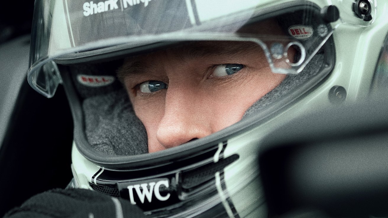 Close-up of a person wearing a racing helmet, focusing intently forward, with visible eyes and helmet branding details.