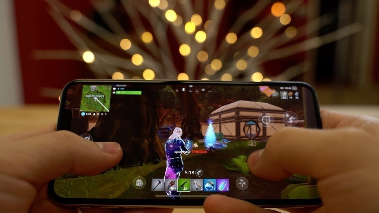 Hands holding a smartphone displaying a video game with a character on-screen, colorful bokeh lights in the background.