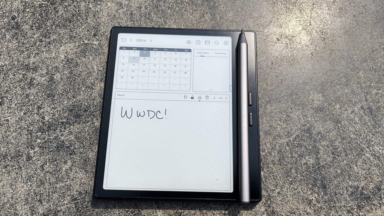 A digital tablet on a textured surface displays a calendar and the handwritten text 'WWDC!' A stylus rests on it.