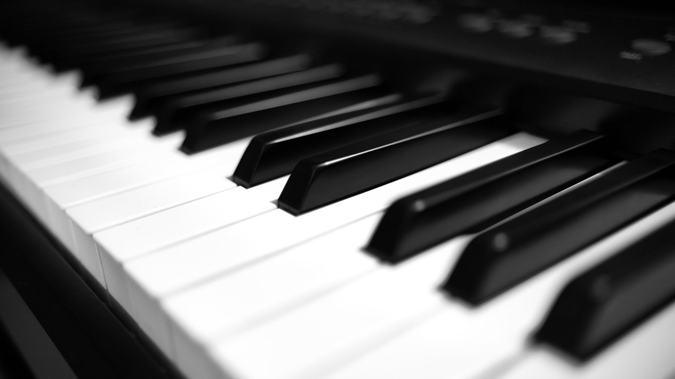 Close-up of piano keys with alternating black and white keys, creating a pattern of shadows and light.