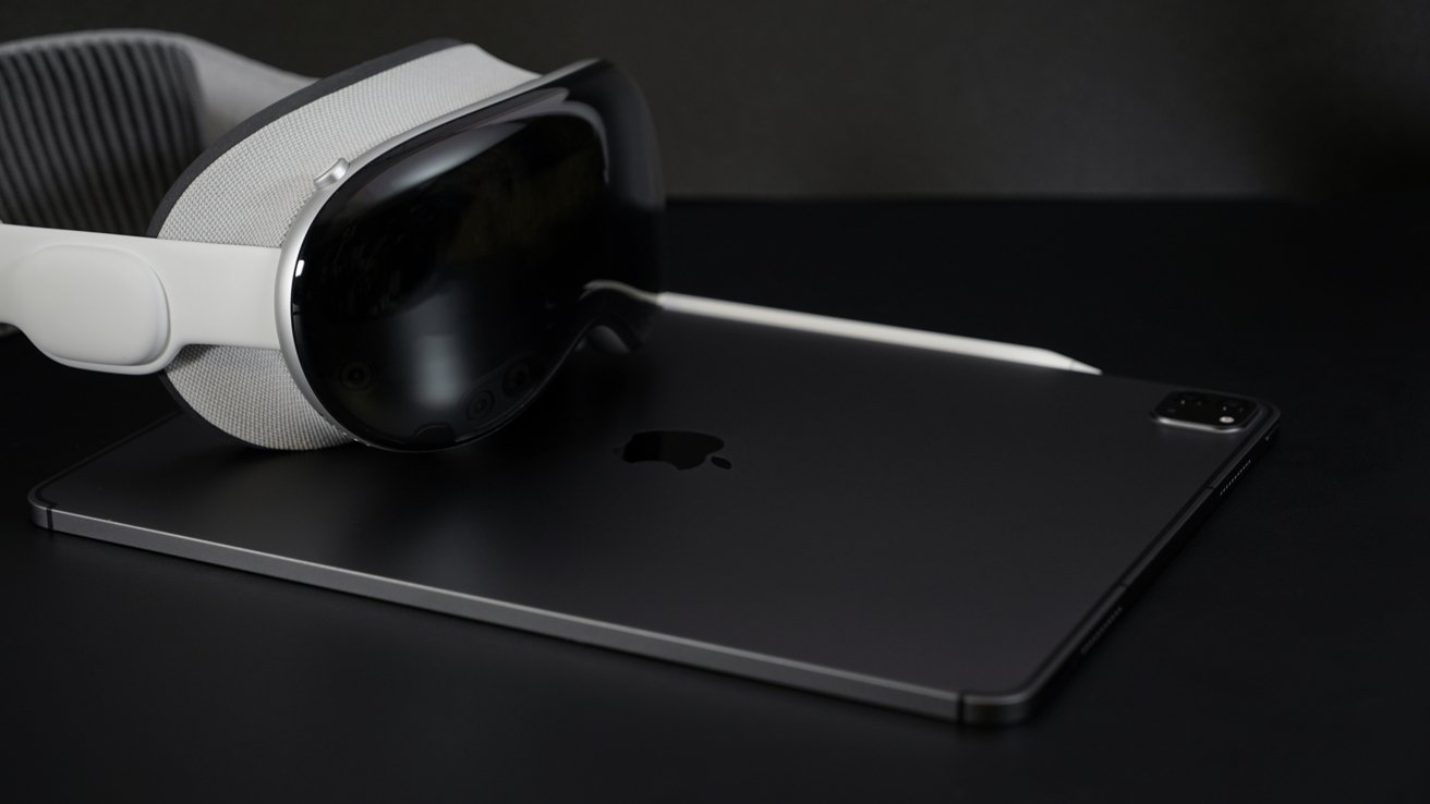 VR headset and stylus resting on a sleek tablet with an Apple logo, all on a dark surface.