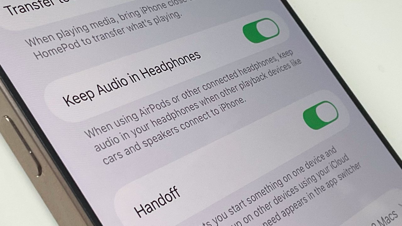 Smartphone screen showing audio settings options with toggle switches for 'Keep Audio in Headphones' and 'Handoff' features, both switched on.