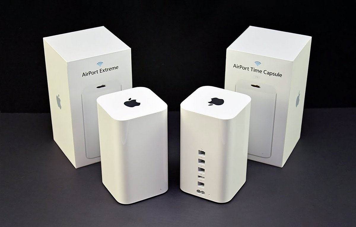 Two white, rectangular devices with Apple logos, surrounded by labeled packaging boxes, appear on a dark surface.