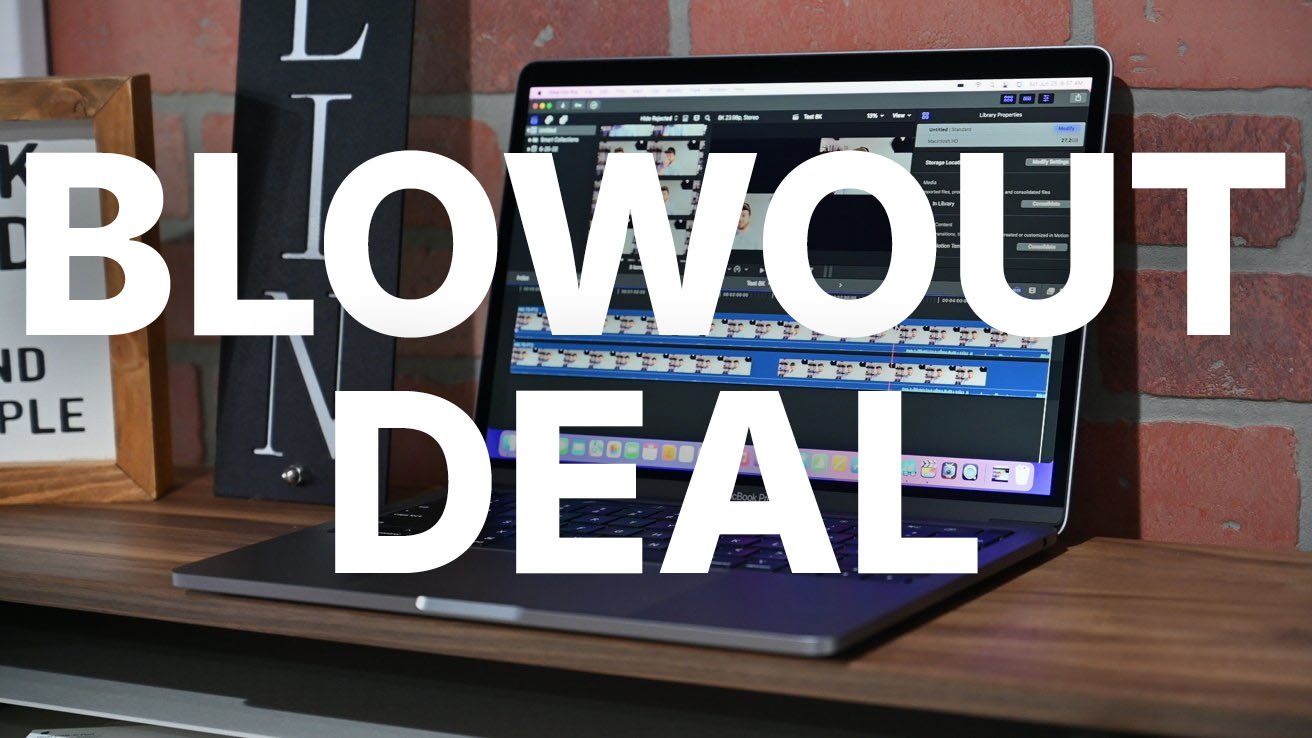 MacBook Pro displaying video editing software on a wooden desk against a brick wall, overlaid with large white text reading 'BLOWOUT DEAL.'