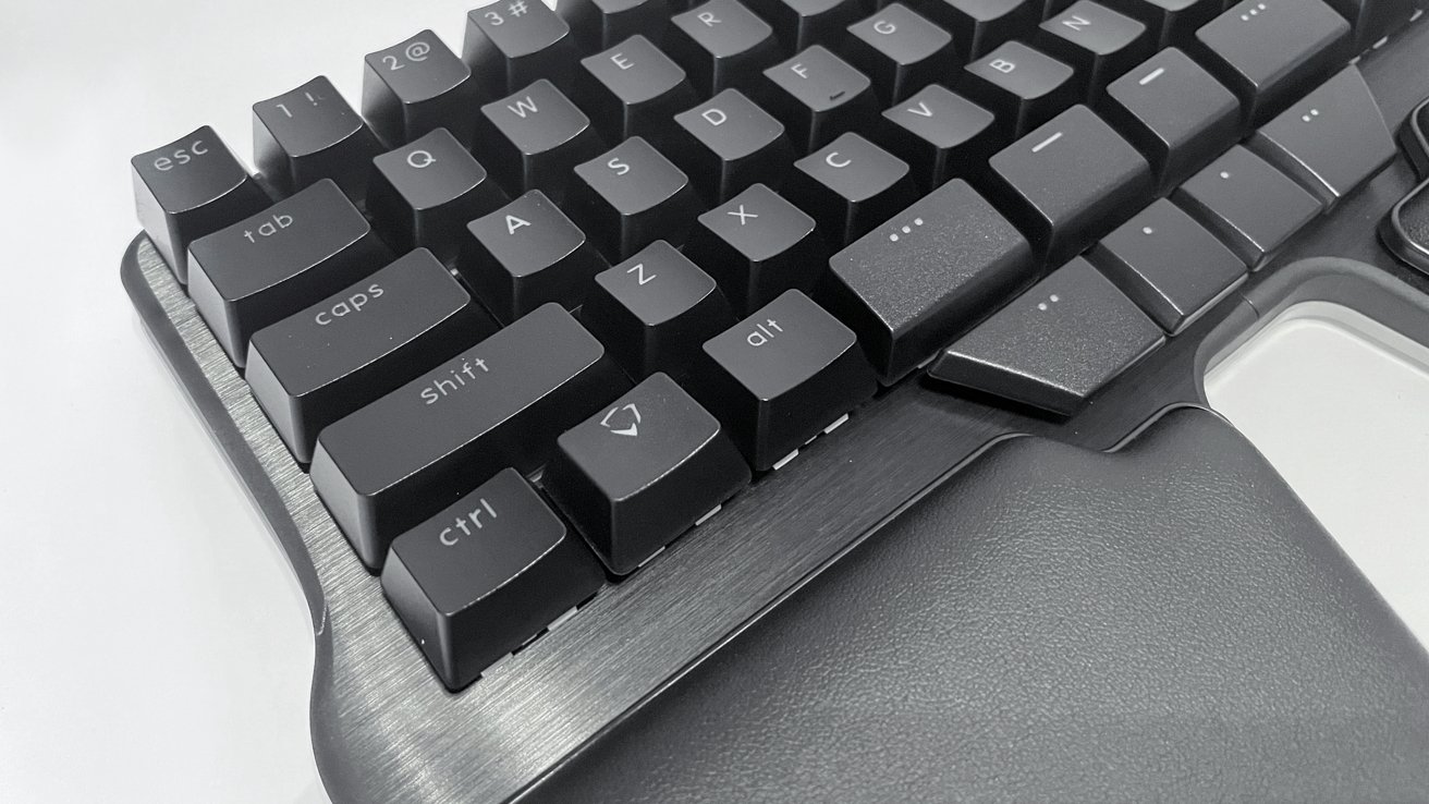 Close-up of a black mechanical keyboard with textured keys and a wrist rest visible on the left side.
