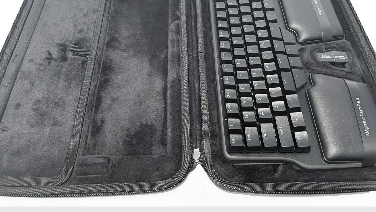 Black keyboard with magnetic palm pads in a gray soft-textured zippered case, viewed from above.