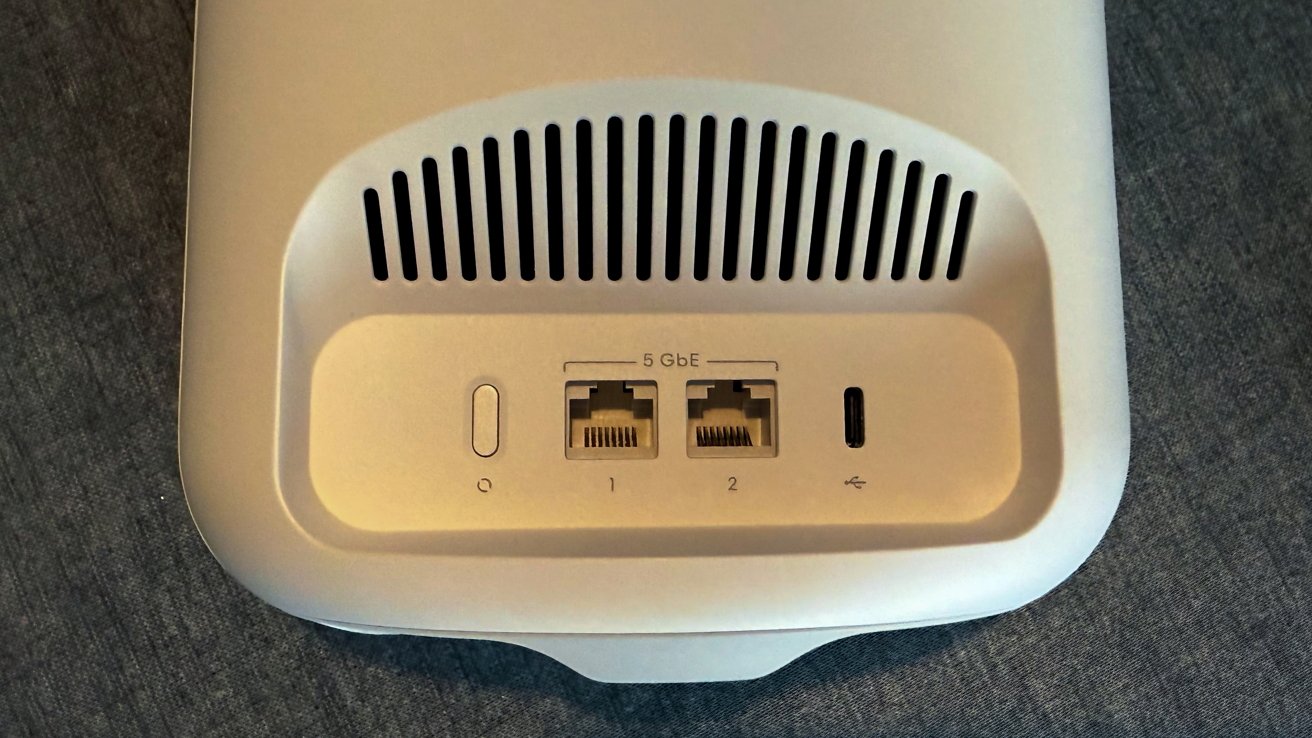 White device with a vent, two Ethernet ports labeled 5 GbE, a USB-C port, and a power button on a gray surface.