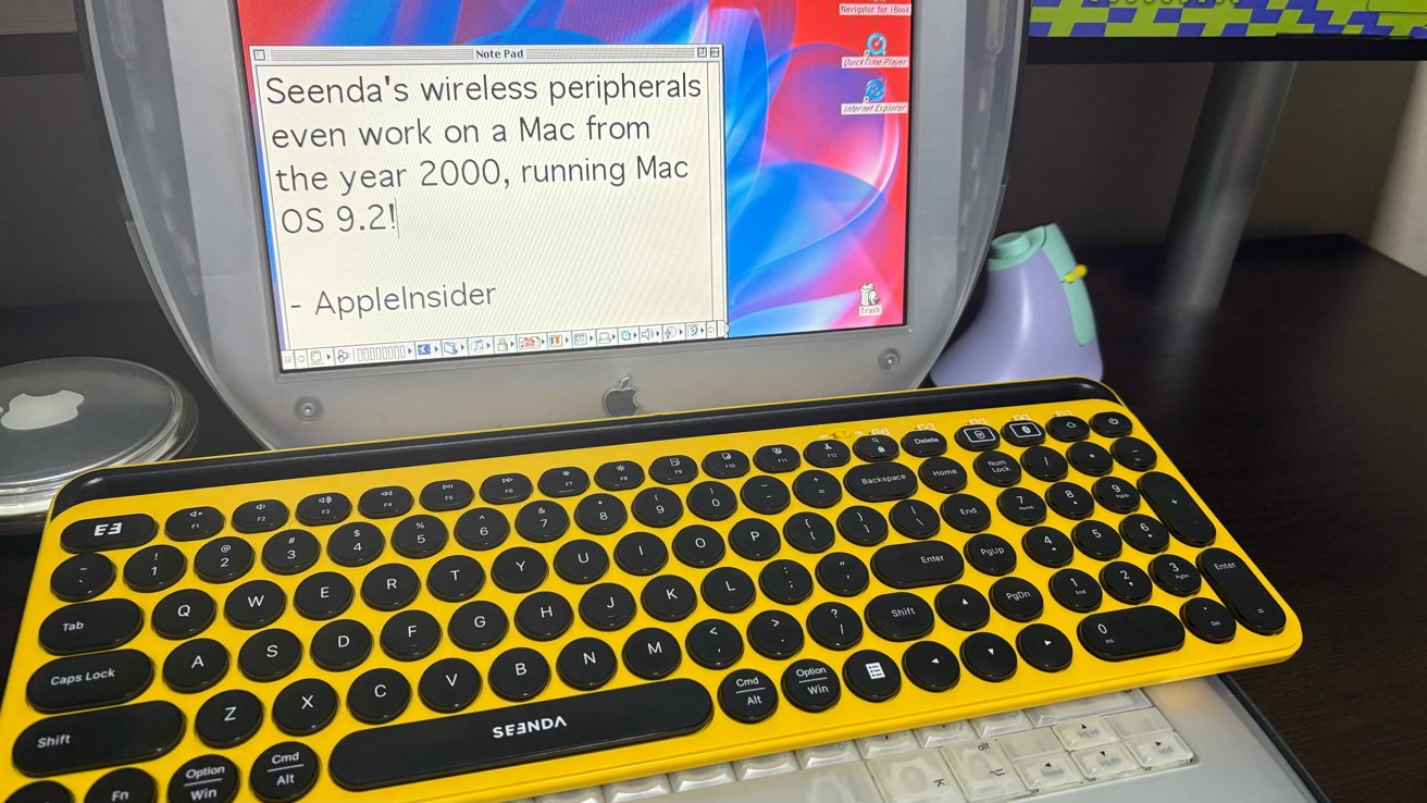 Yellow wireless keyboard on a vintage Mac laptop running Mac OS 9.2 with text stating compatibility.
