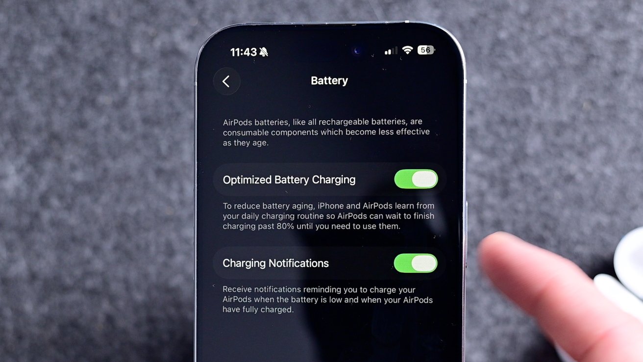 Smartphone screen showing battery settings for AirPods with options for Optimized Battery Charging and Charging Notifications enabled, against a textured background.