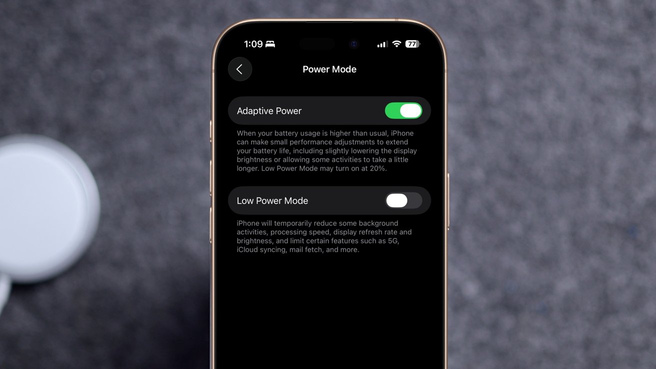 Smartphone screen displaying power mode settings with options for Adaptive Power and Low Power Mode against a blurred background.