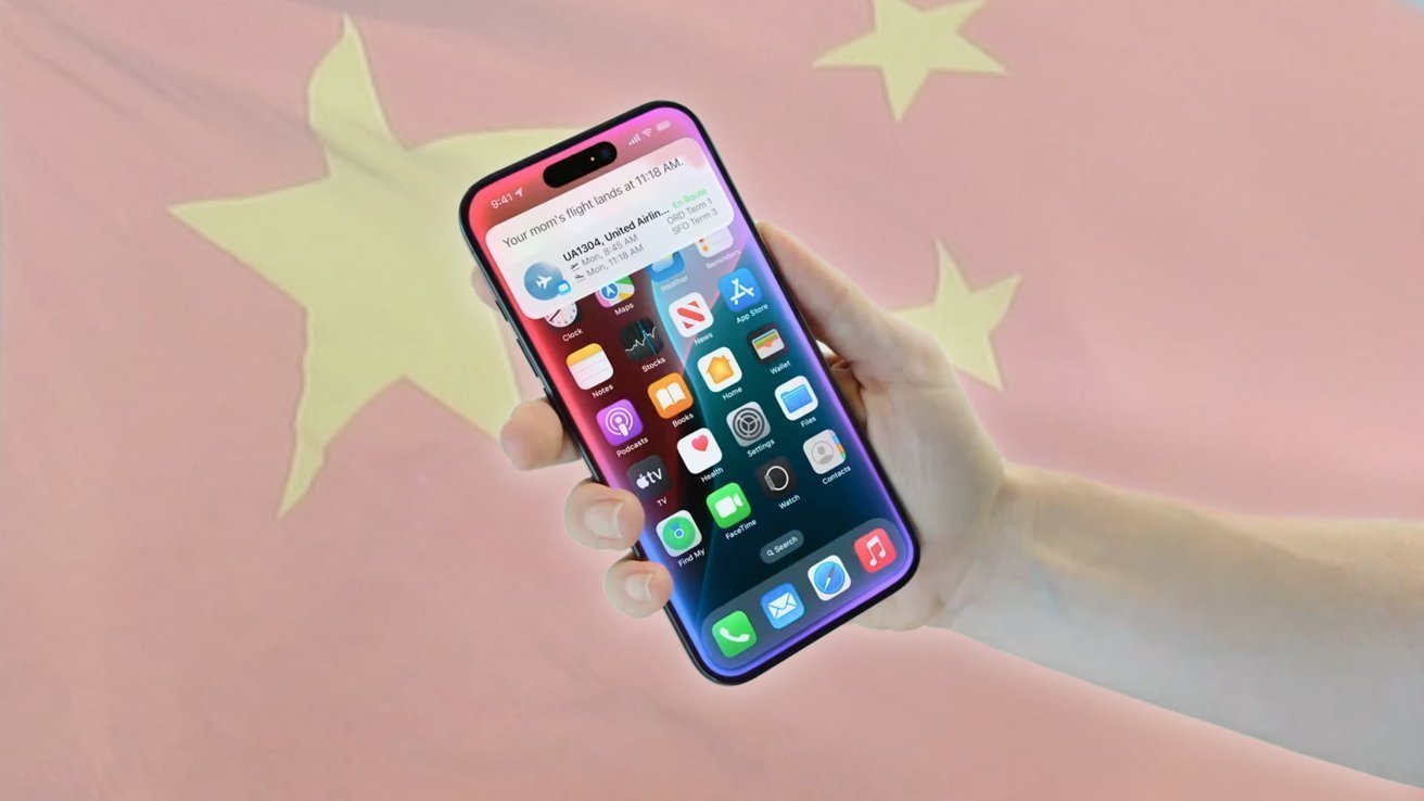 Hand holding a smartphone displaying app icons and a flight notification, with a blurred red flag featuring yellow stars in the background.