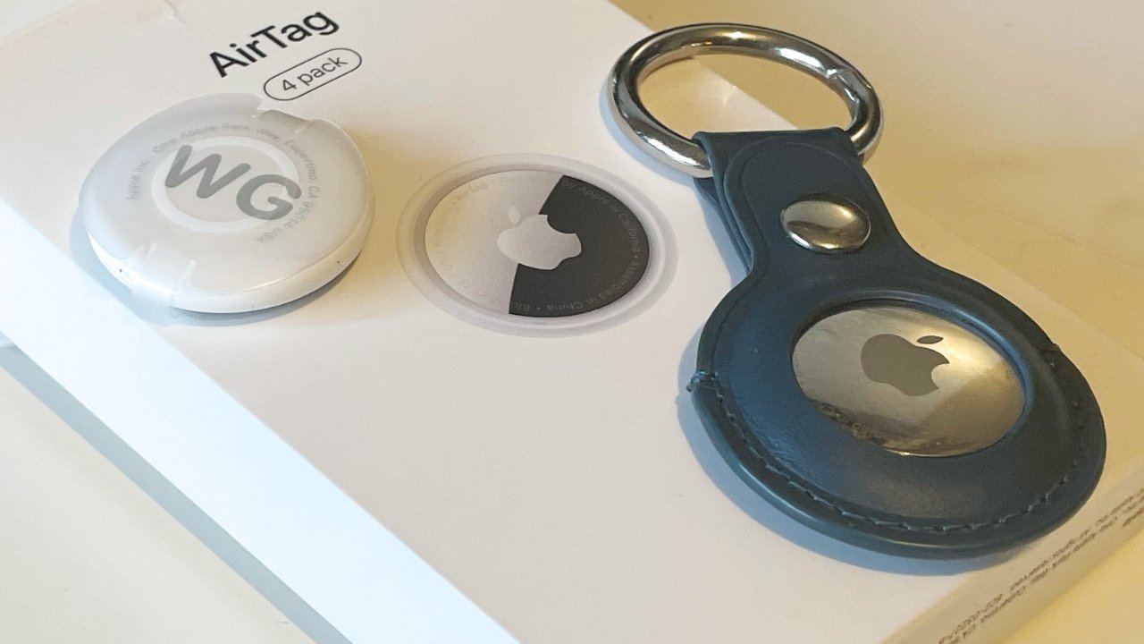 Apple AirTag package with an open capsule, a keychain holder, and an AirTag featuring a silver Apple logo.