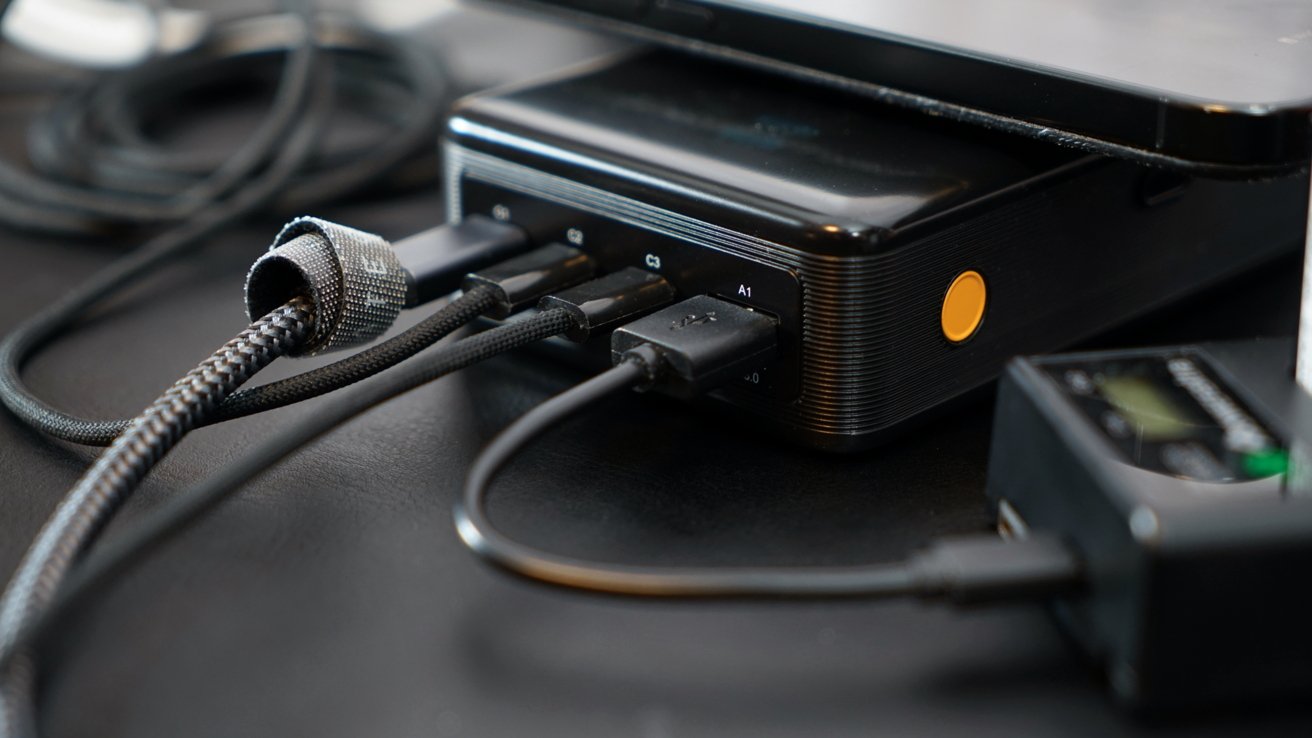 Electronic device with multiple USB cables plugged in; cables feature braided designs.
