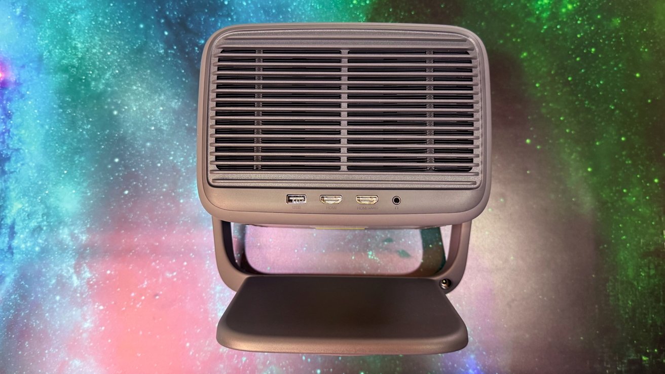 Gray electronic device with USB, HDMI ports, and a headphone jack, set against a colorful galaxy-themed background.