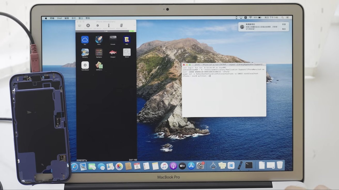 Laptop displaying macOS desktop with terminal open, connected to a disassembled smartphone on the left. Wires are visible connecting both devices.