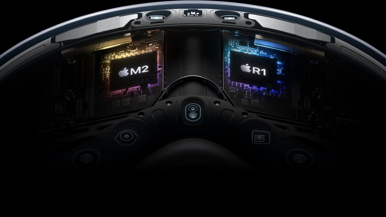Interior view of a headset showing two Apple chips labeled M2 and R1, surrounded by circuitry and components.