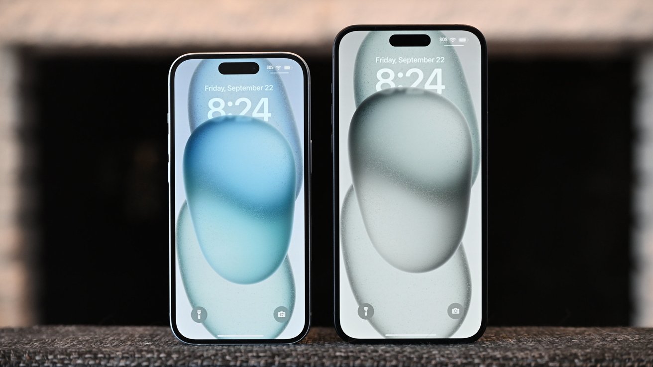 Two smartphones side by side on a textured surface, displaying different abstract wallpapers and the same time and date, with a blurred background.
