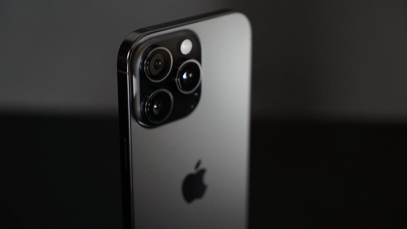 Smartphone with three rear camera lenses and an Apple logo on a dark background.
