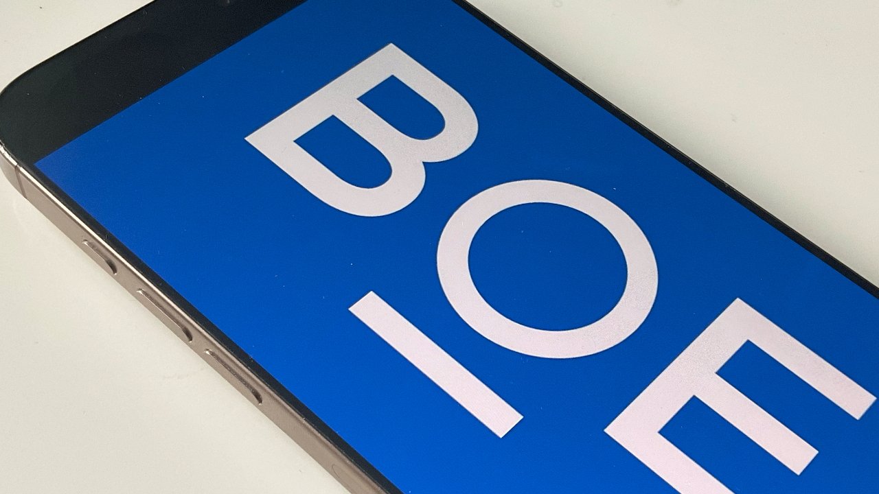 Smartphone displaying large white letters 'BOE' on a blue screen, partially visible, on a white surface with its edges slightly visible.