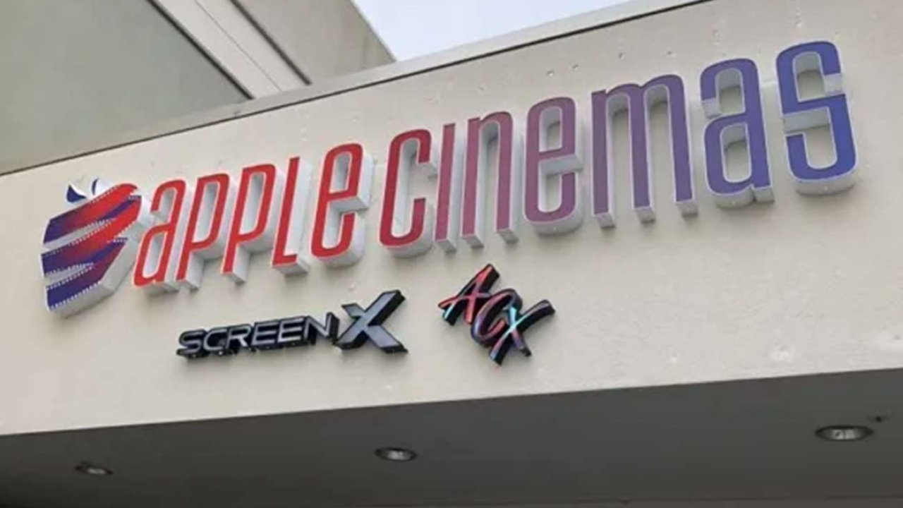Sign reading 'Apple Cinemas' with a stylized apple logo, featuring 'ScreenX' and 'ACX' logos beneath on a light background.
