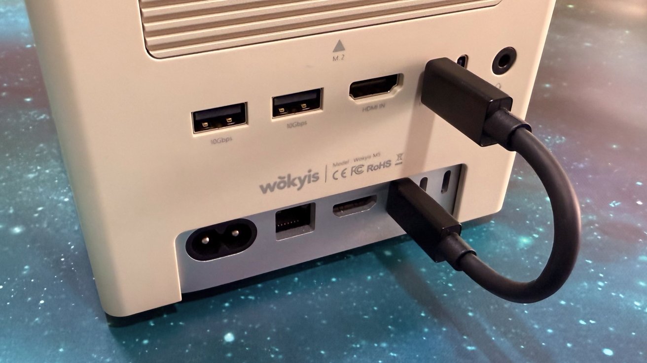 Back of a computer with various ports including USB HDMI power and network A cable is plugged into an HDMI port set on a starry background
