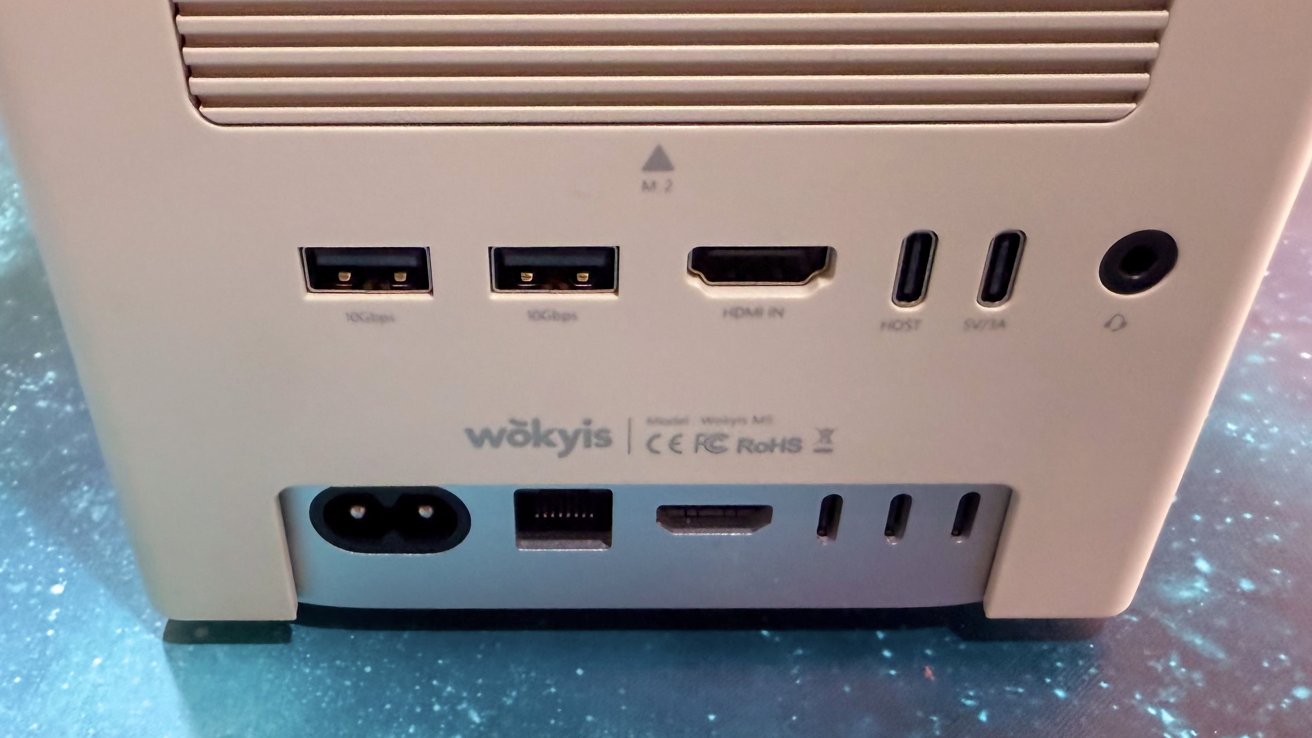 White electronic device with two USB ports HDMI input two USB-C ports power outlet Ethernet and additional HDMI and USB-C ports on a starry background